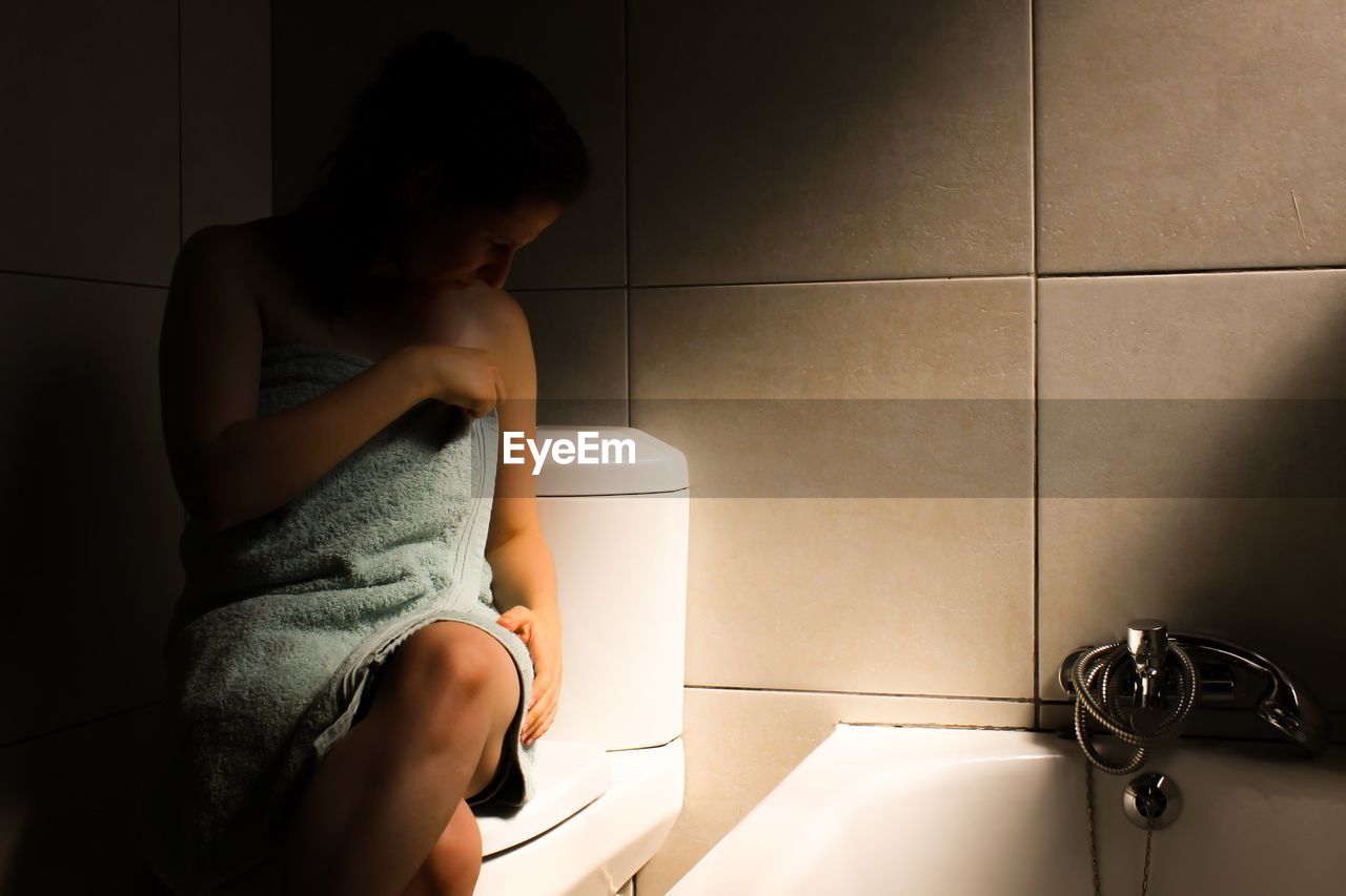 Woman wrapped in towel at bathroom