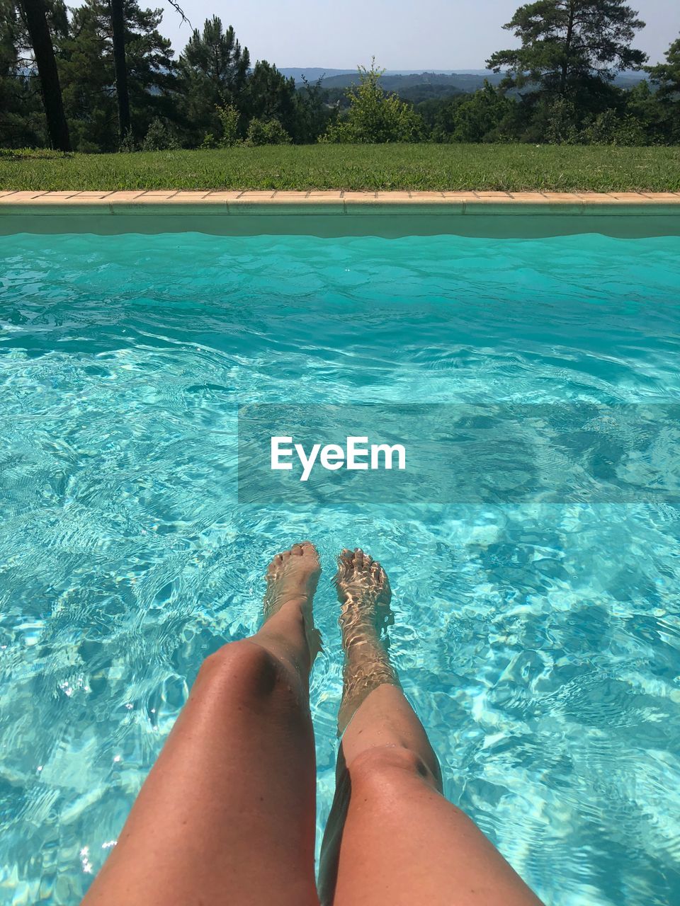 LOW SECTION OF WOMAN RELAXING IN POOL