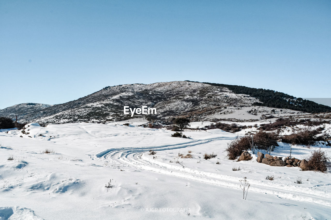 Scenic view of snowcapped mountains against clear blue sky