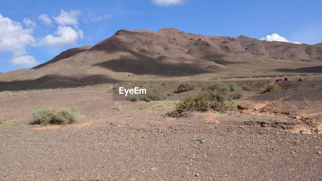 Scenic view of desert against blue sky