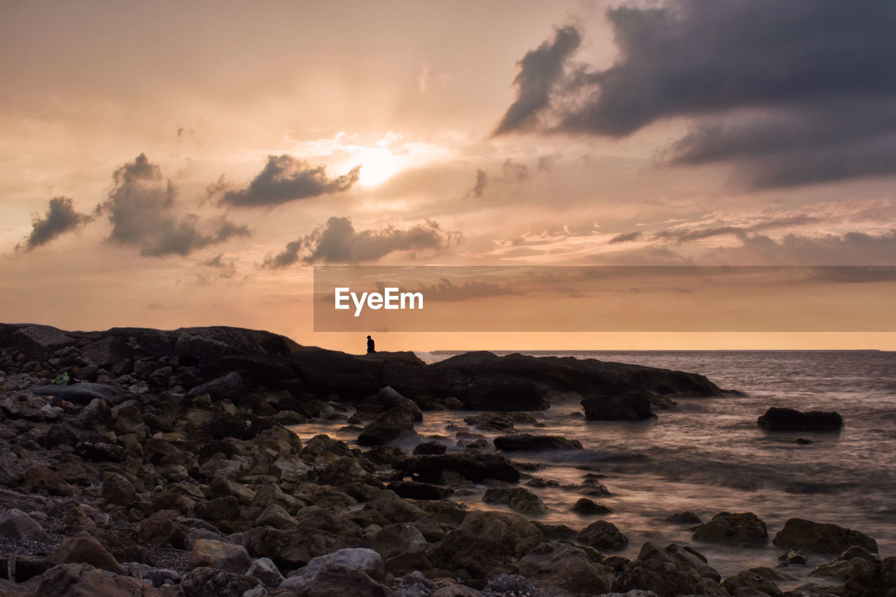 SCENIC VIEW OF SEA AGAINST SKY AT SUNSET