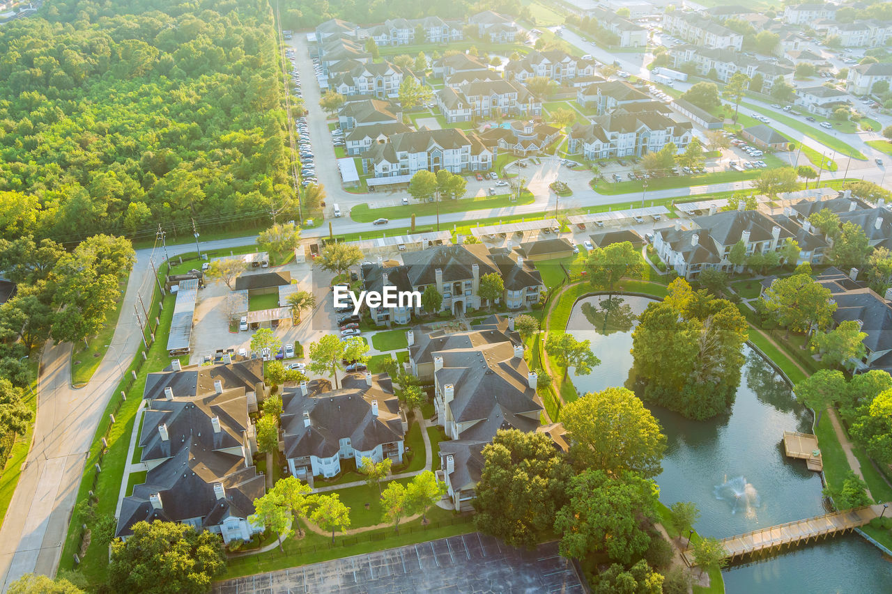 HIGH ANGLE VIEW OF TREES BY PLANTS AND BUILDING