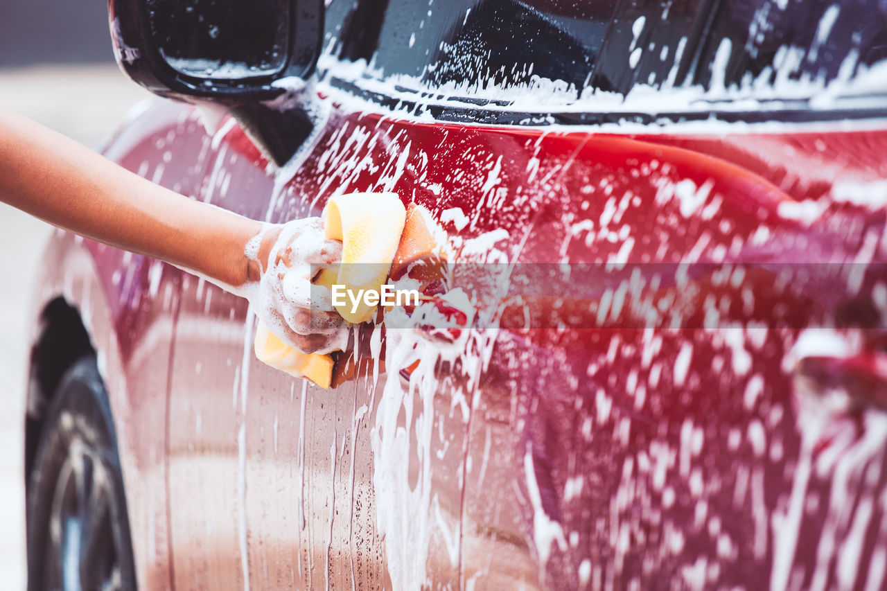 Cropped image of hand washing car