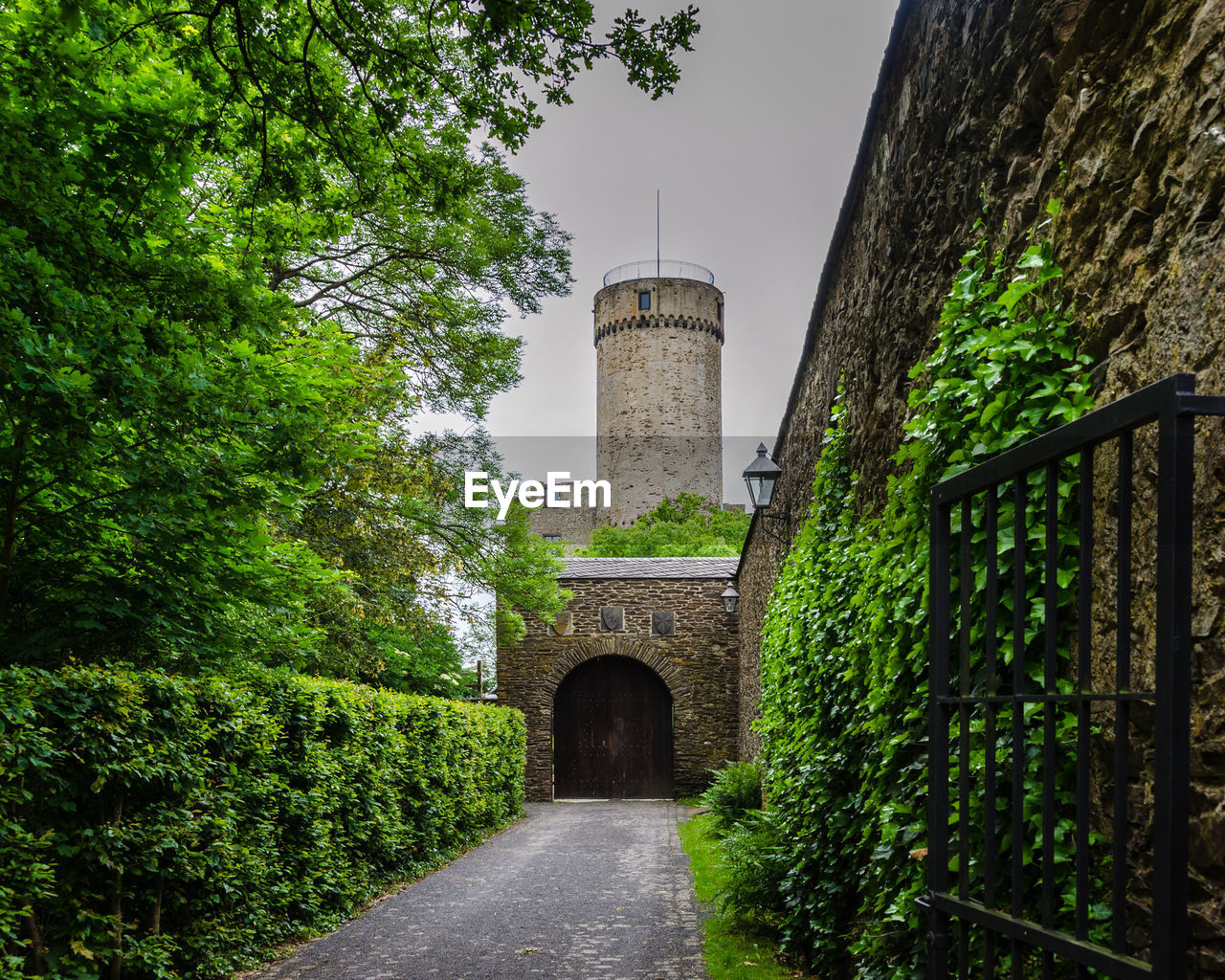 Footpath leading towards castle against sky