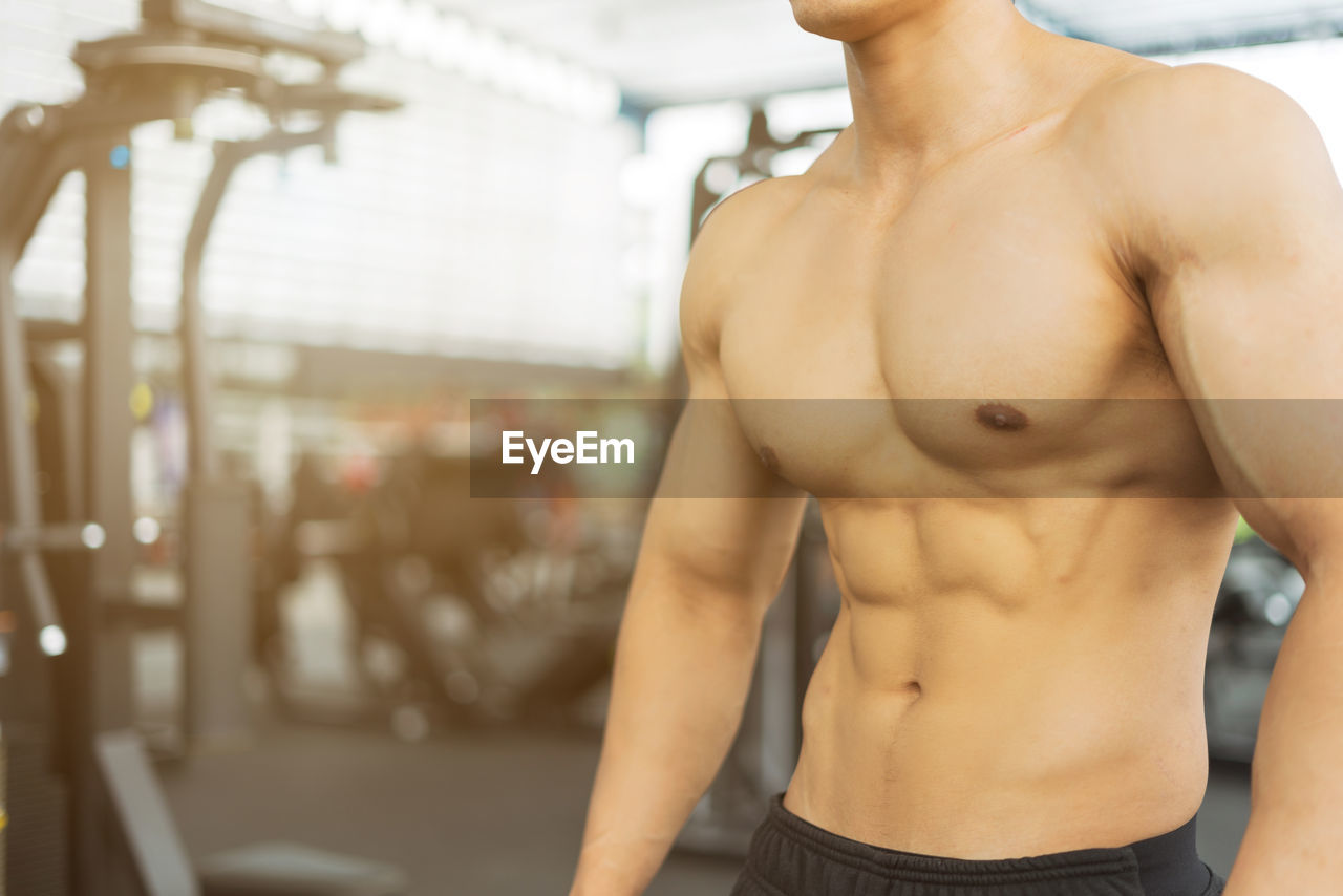 Shirtless man exercising at gym