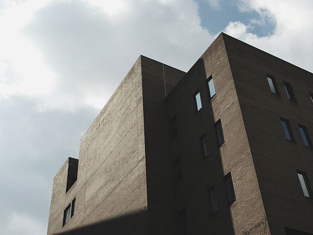 LOW ANGLE VIEW OF OFFICE BUILDING AGAINST CLOUDY SKY