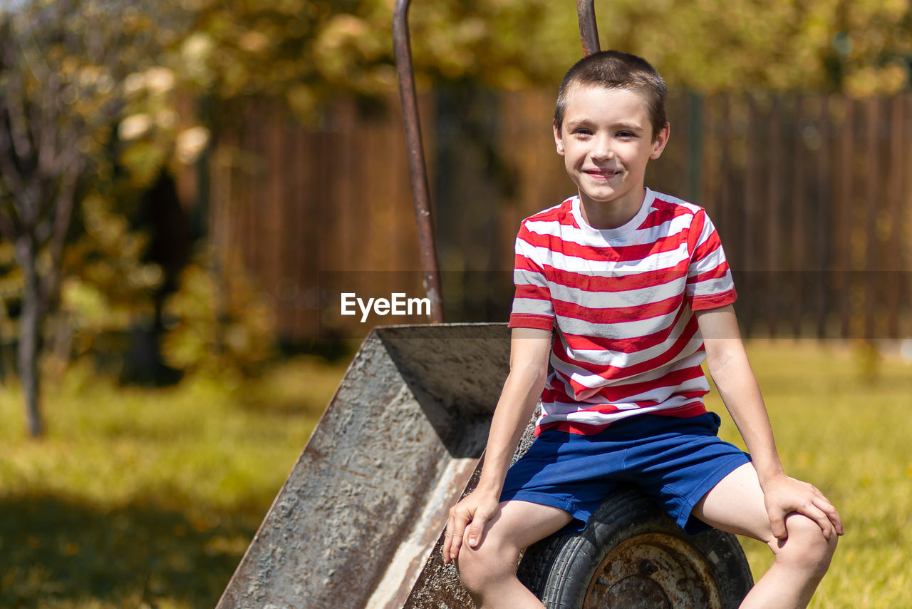 PORTRAIT OF BOY SITTING OUTDOORS