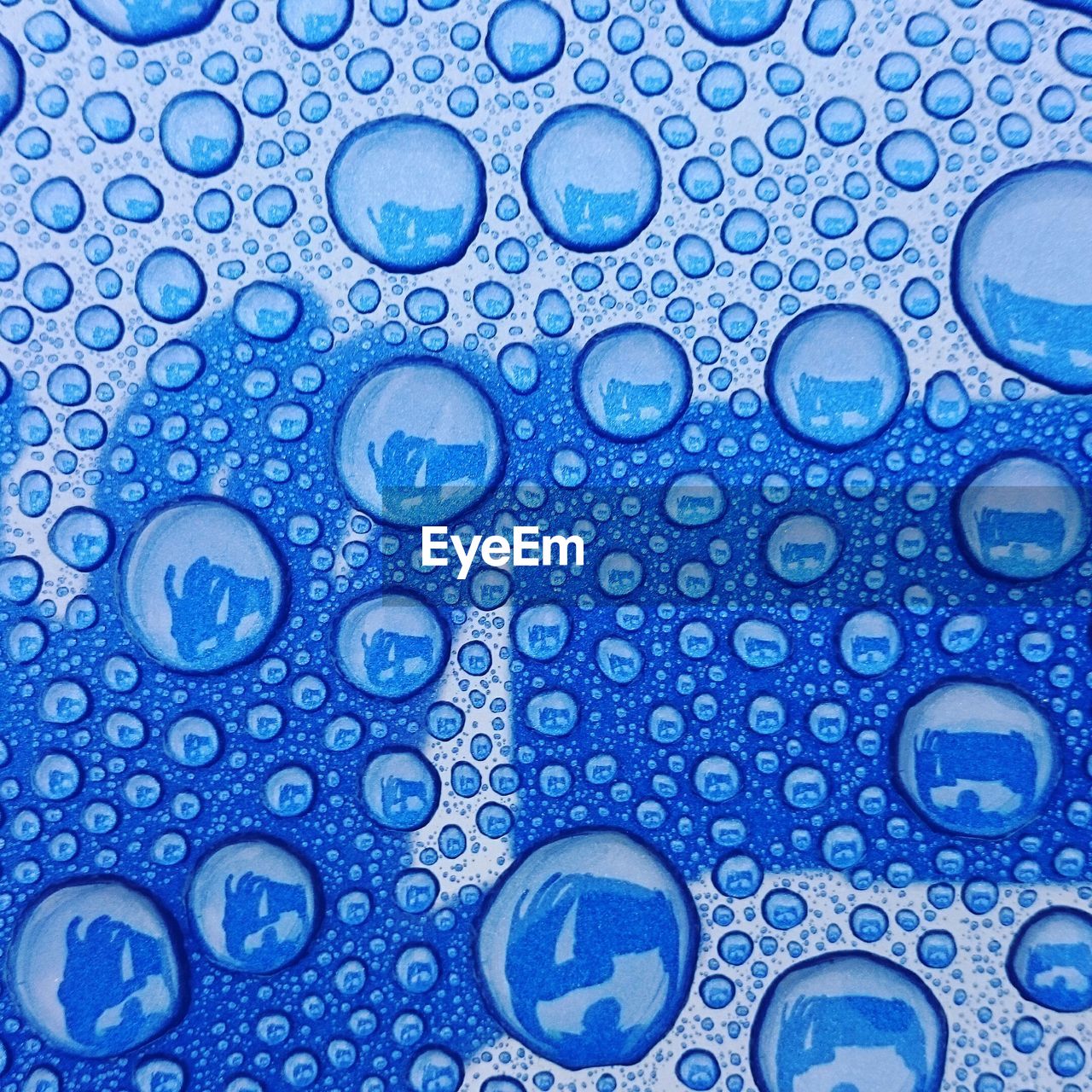 Full frame shot of raindrops on blue metal