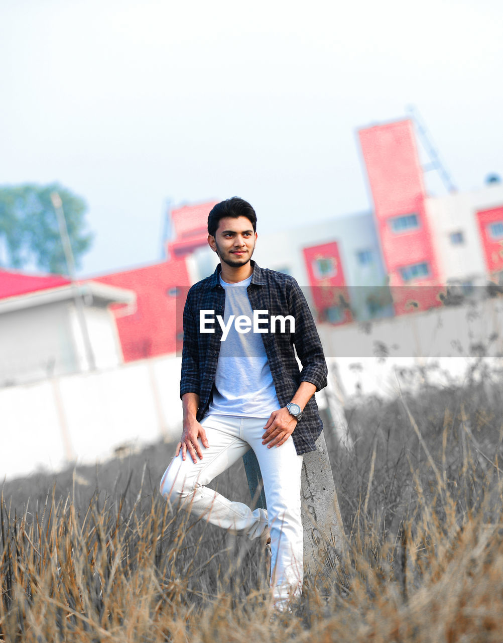 Young man standing on field against sky