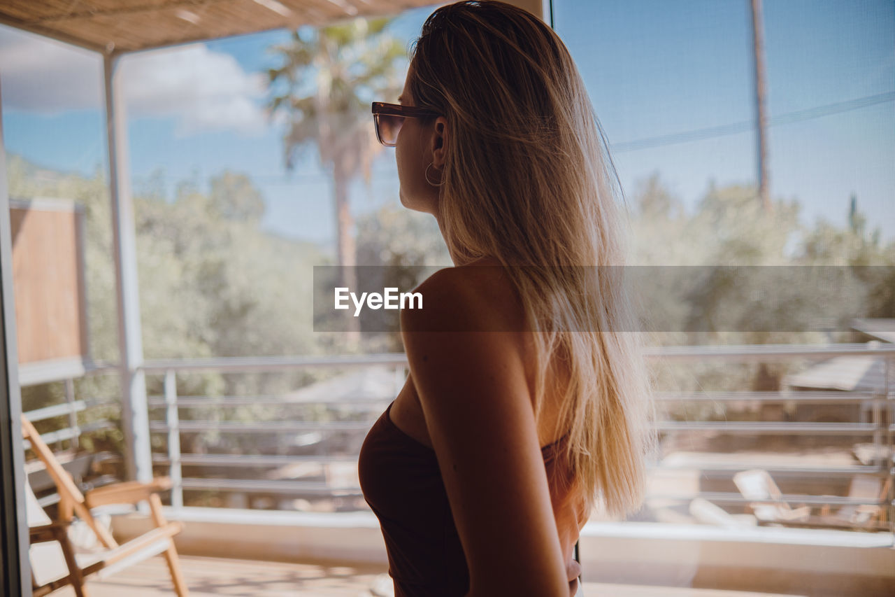 Side view of young woman sitting on railing