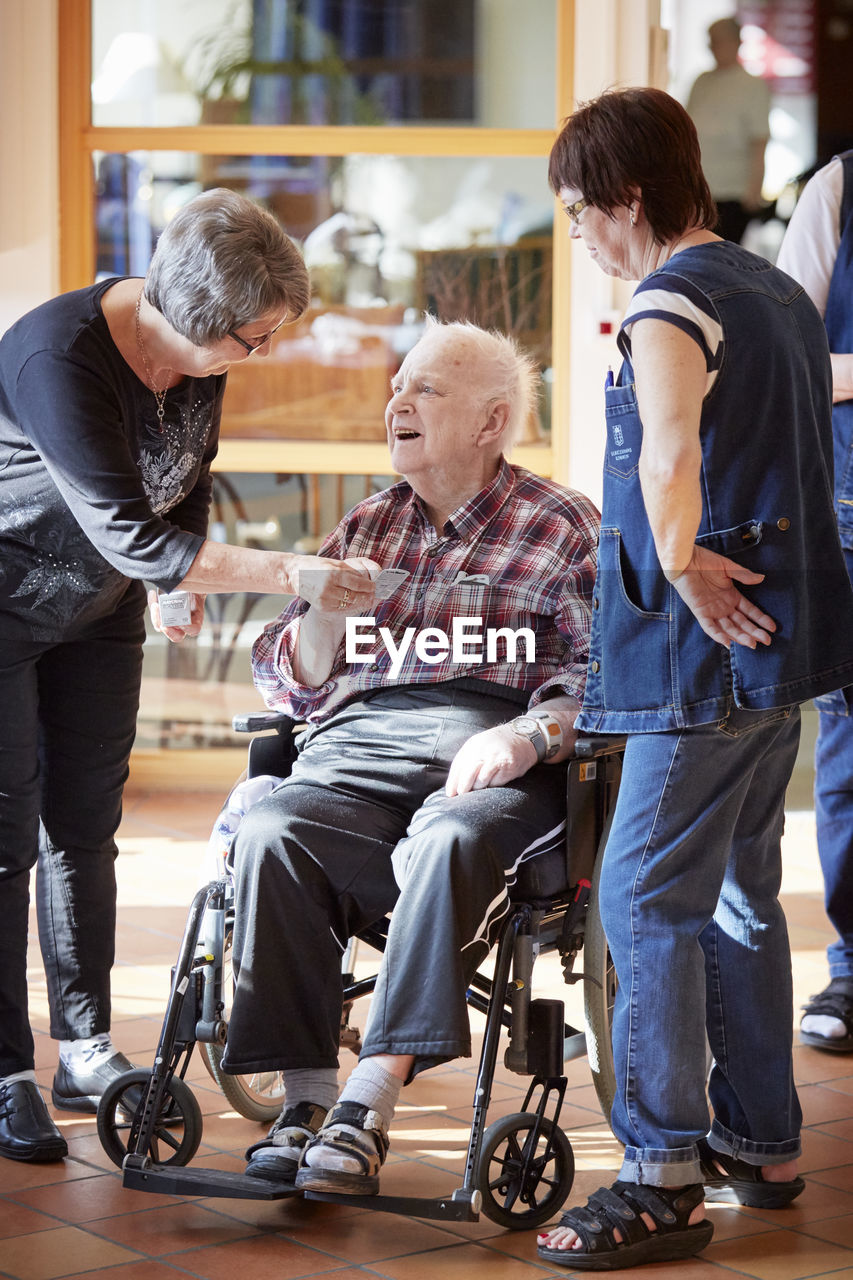 Nurses with smiling senior man in care home