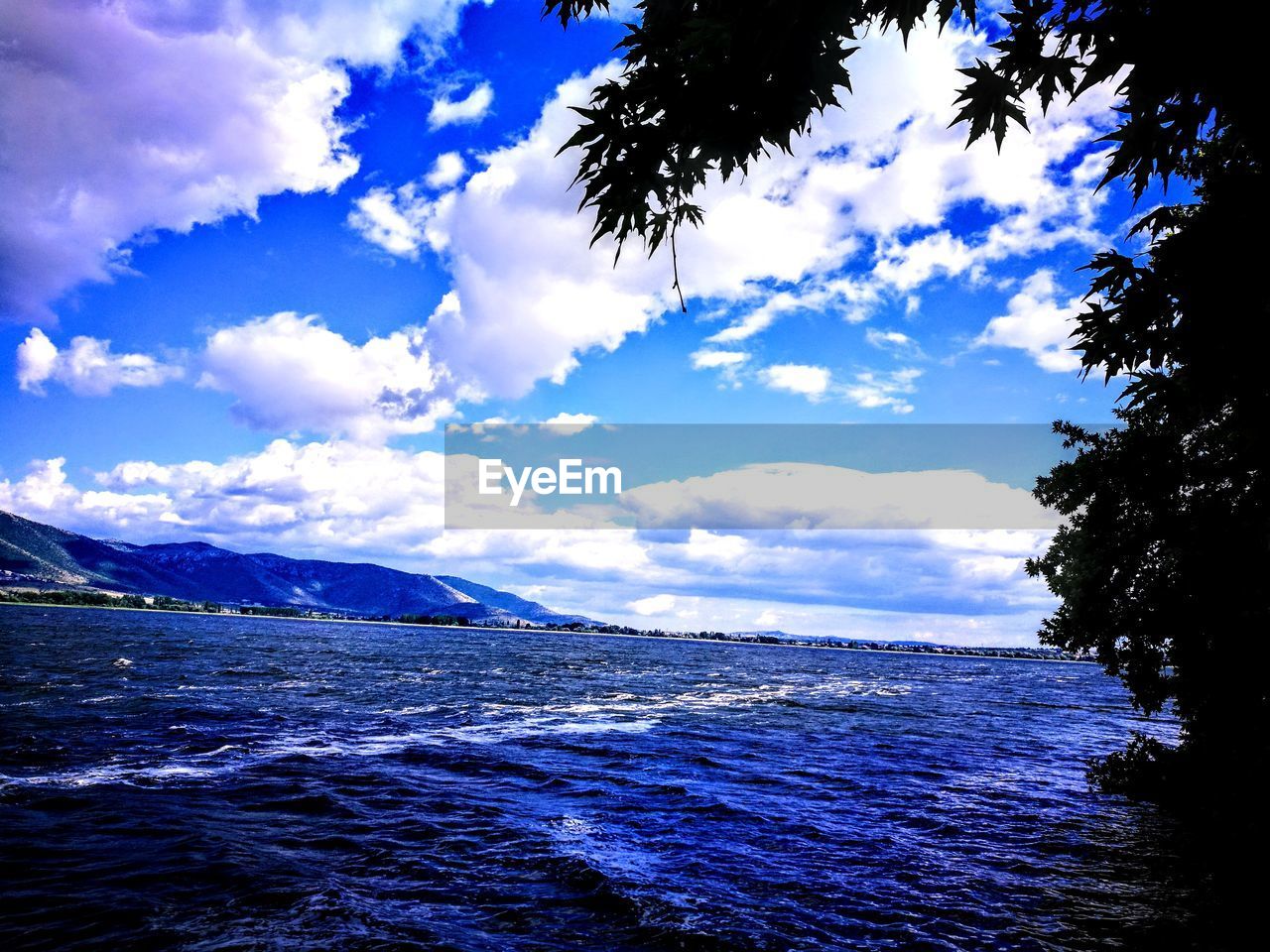 SCENIC VIEW OF SEA BY MOUNTAIN AGAINST SKY