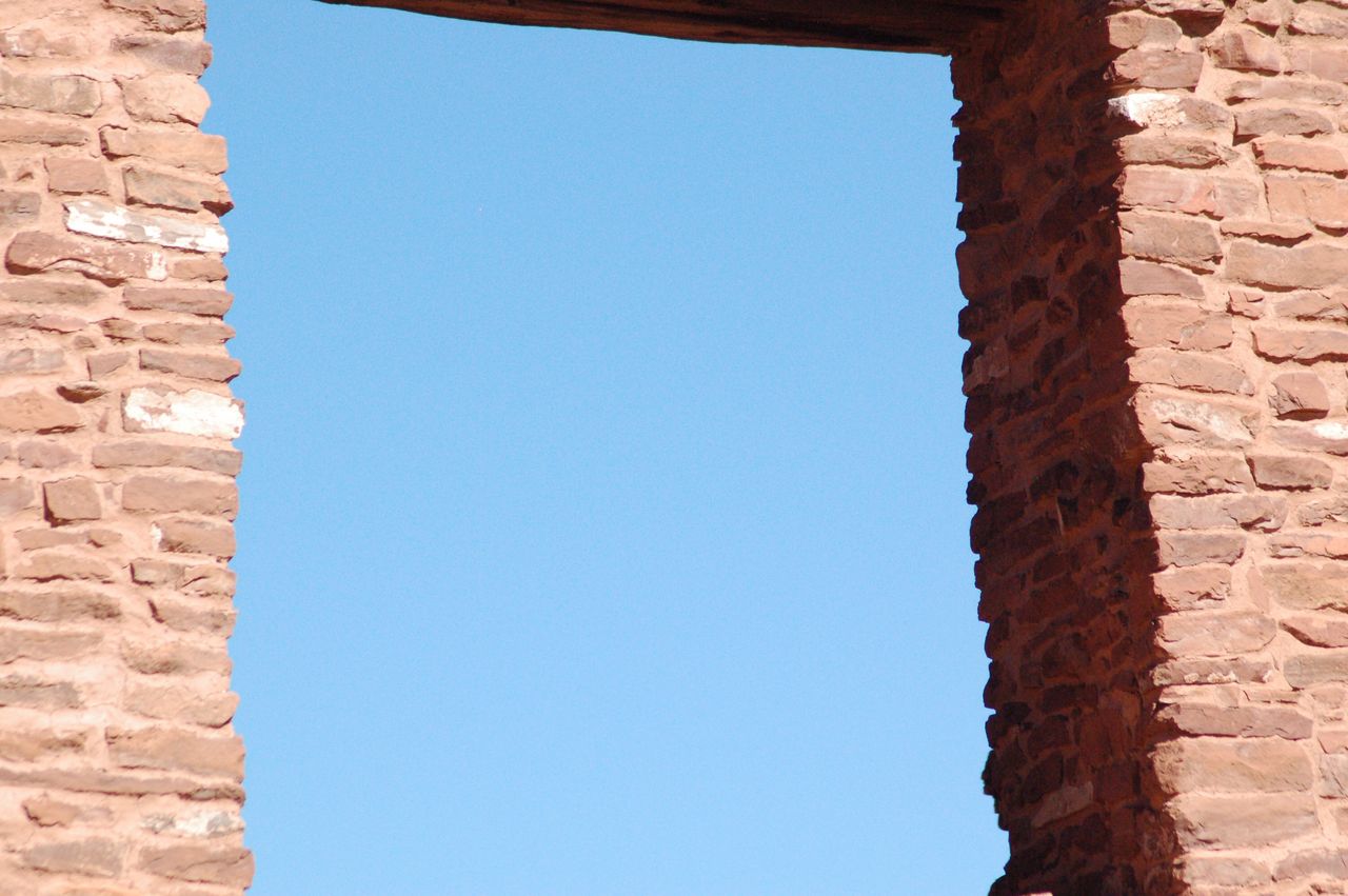 LOW ANGLE VIEW OF WALL AGAINST CLEAR BLUE SKY