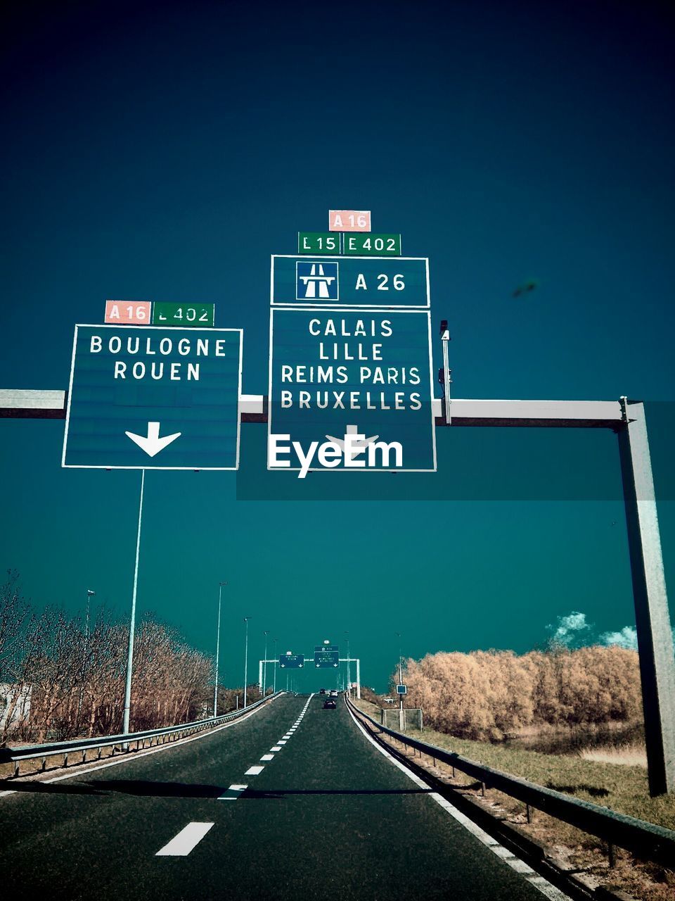 Road sign on highway against clear sky