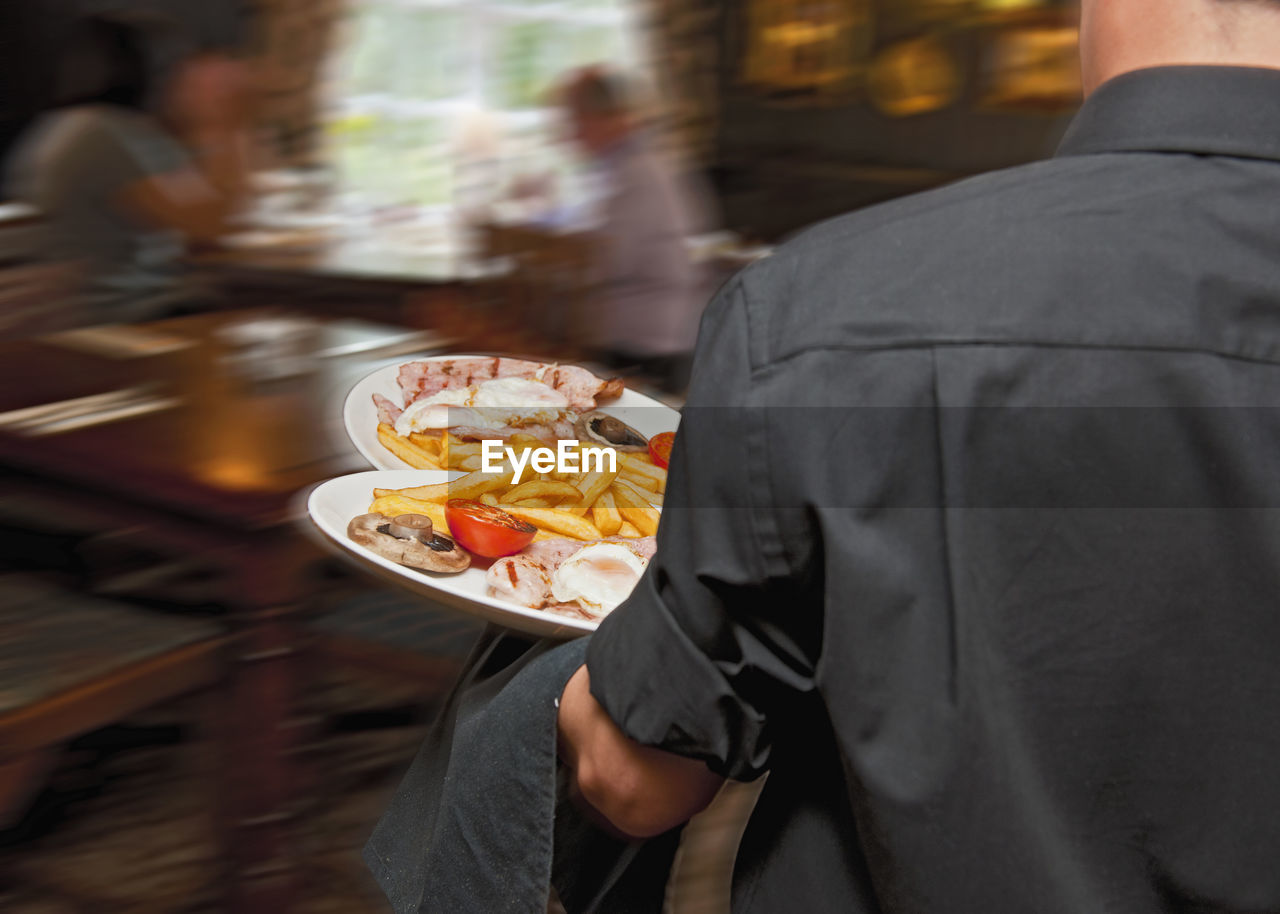 Waiter serving food at british pub