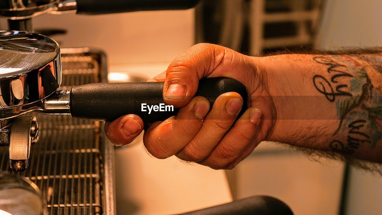 Cropped hand of man making coffee