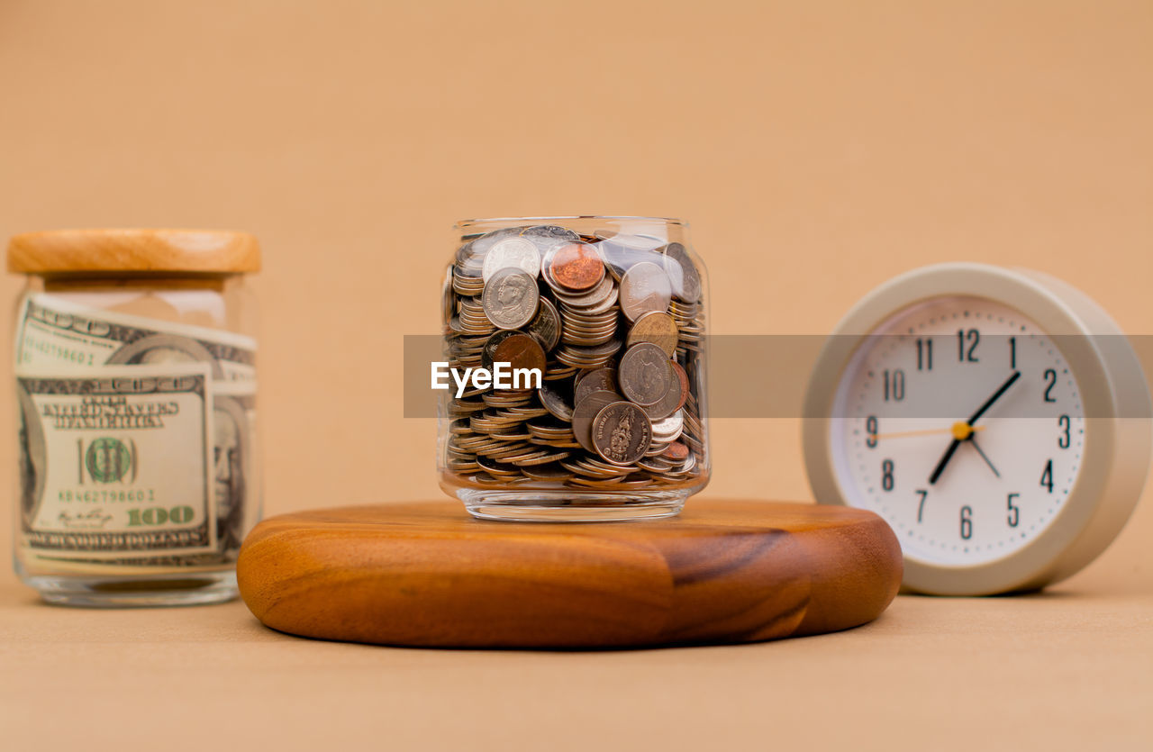 clock, time, studio shot, business, indoors, finance, currency, alarm clock, no people, colored background, wealth, wood, savings, coin