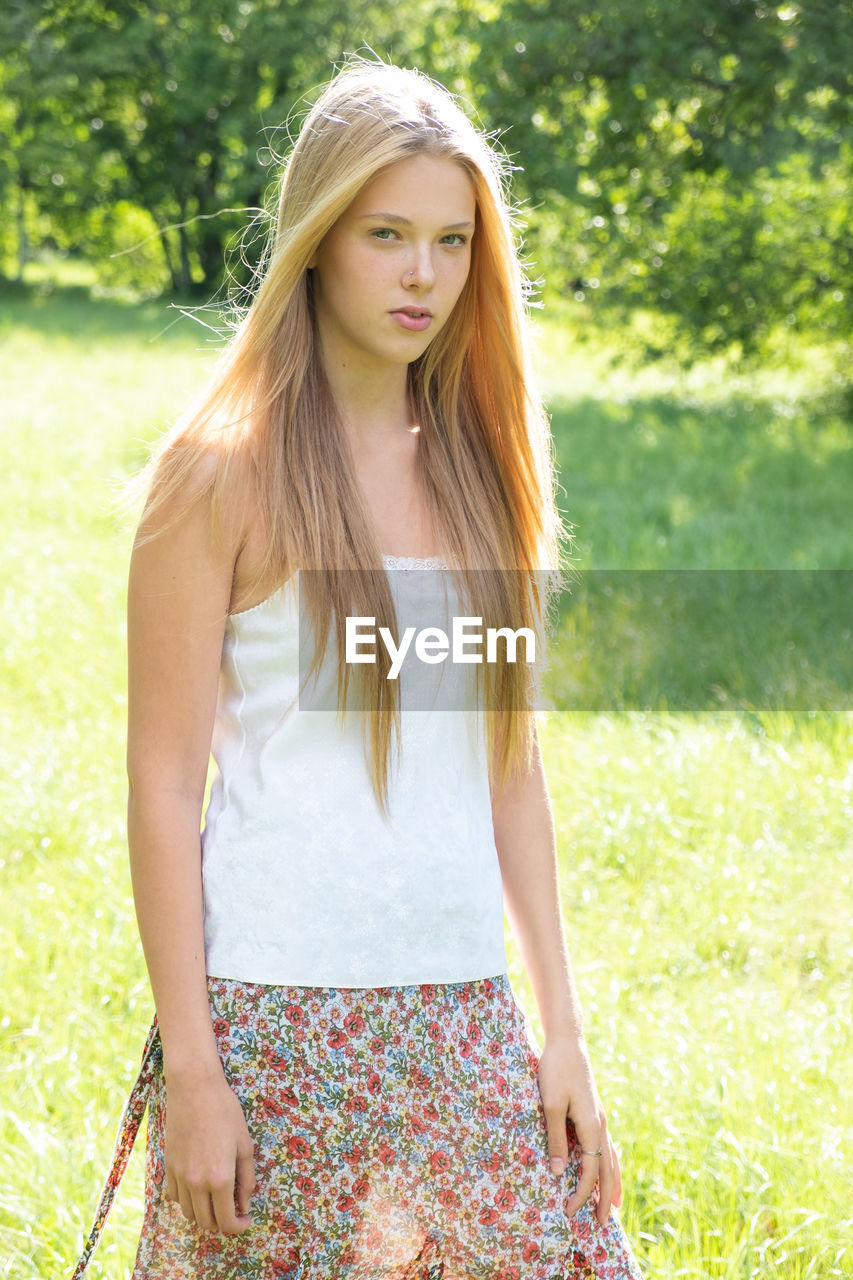 Portrait of beautiful teenage girl standing on field