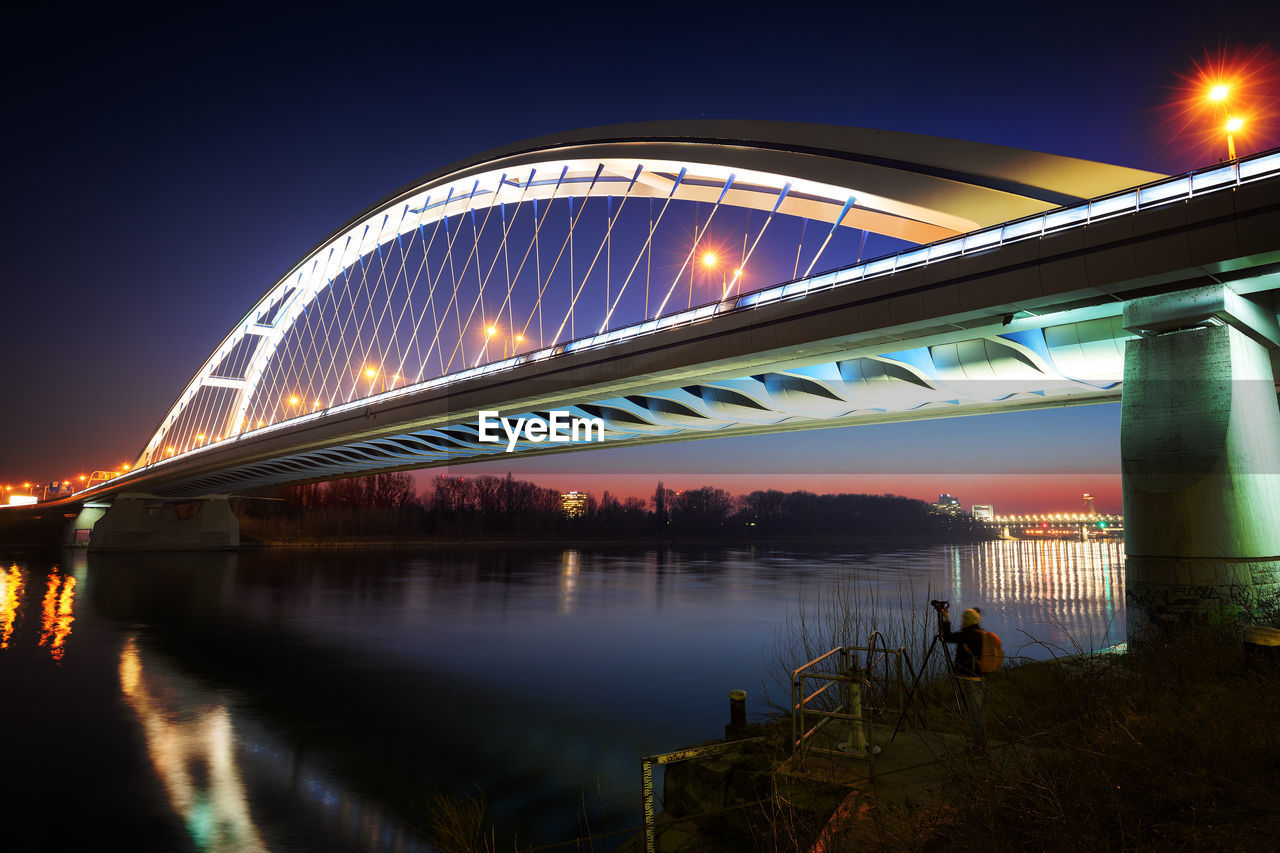 ARCH BRIDGE OVER RIVER AT NIGHT