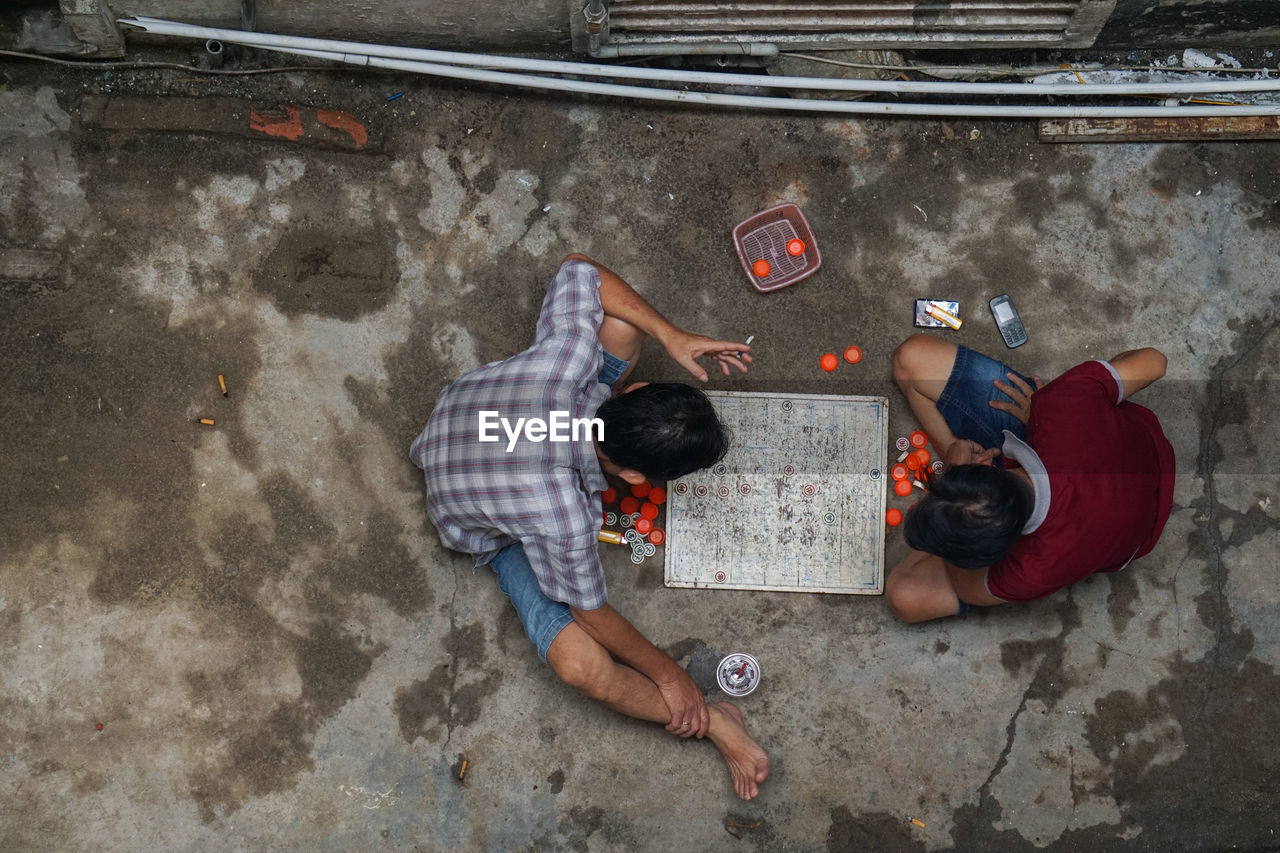 HIGH ANGLE VIEW OF MEN LYING ON FLOOR