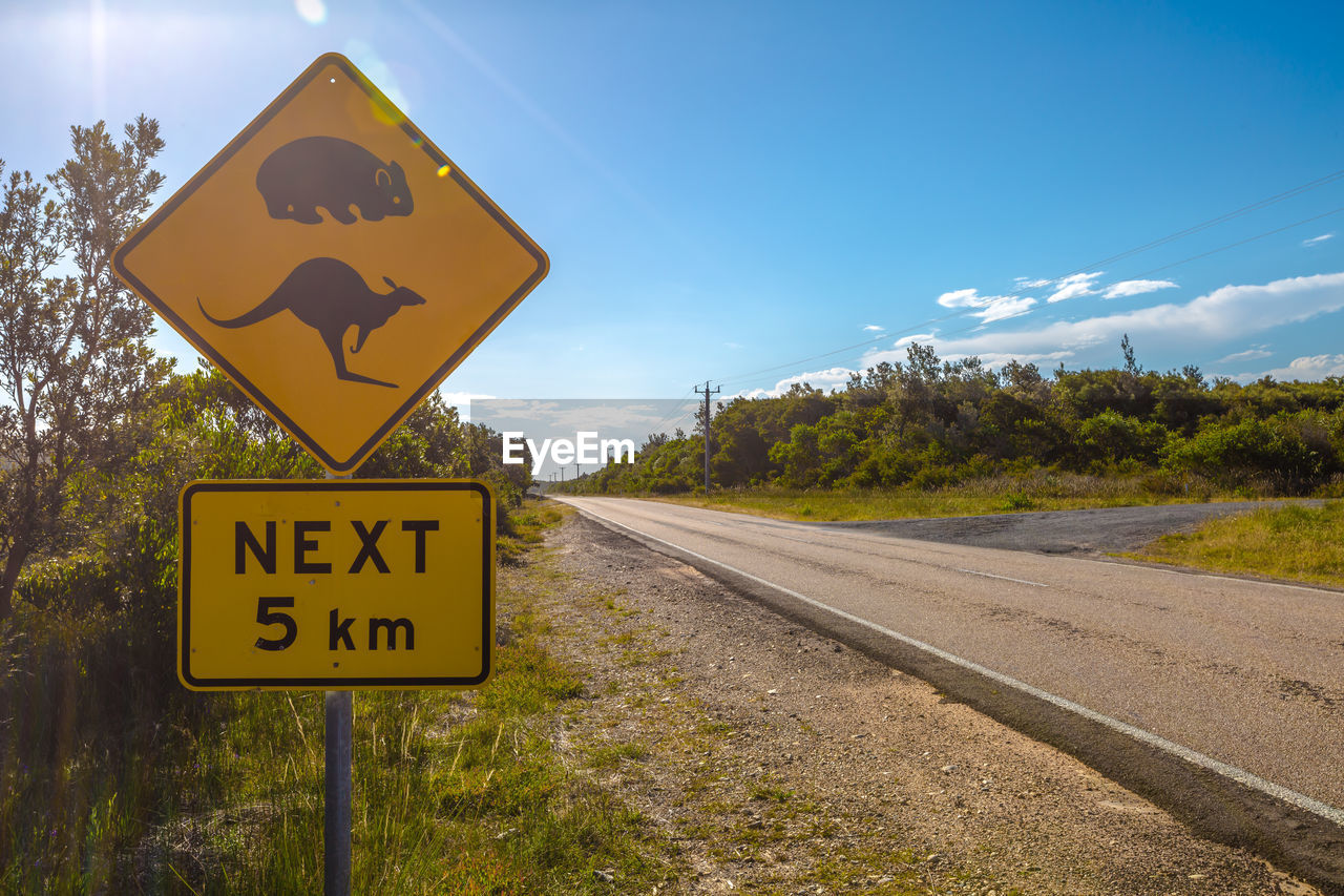 Close-up of road sign against sky