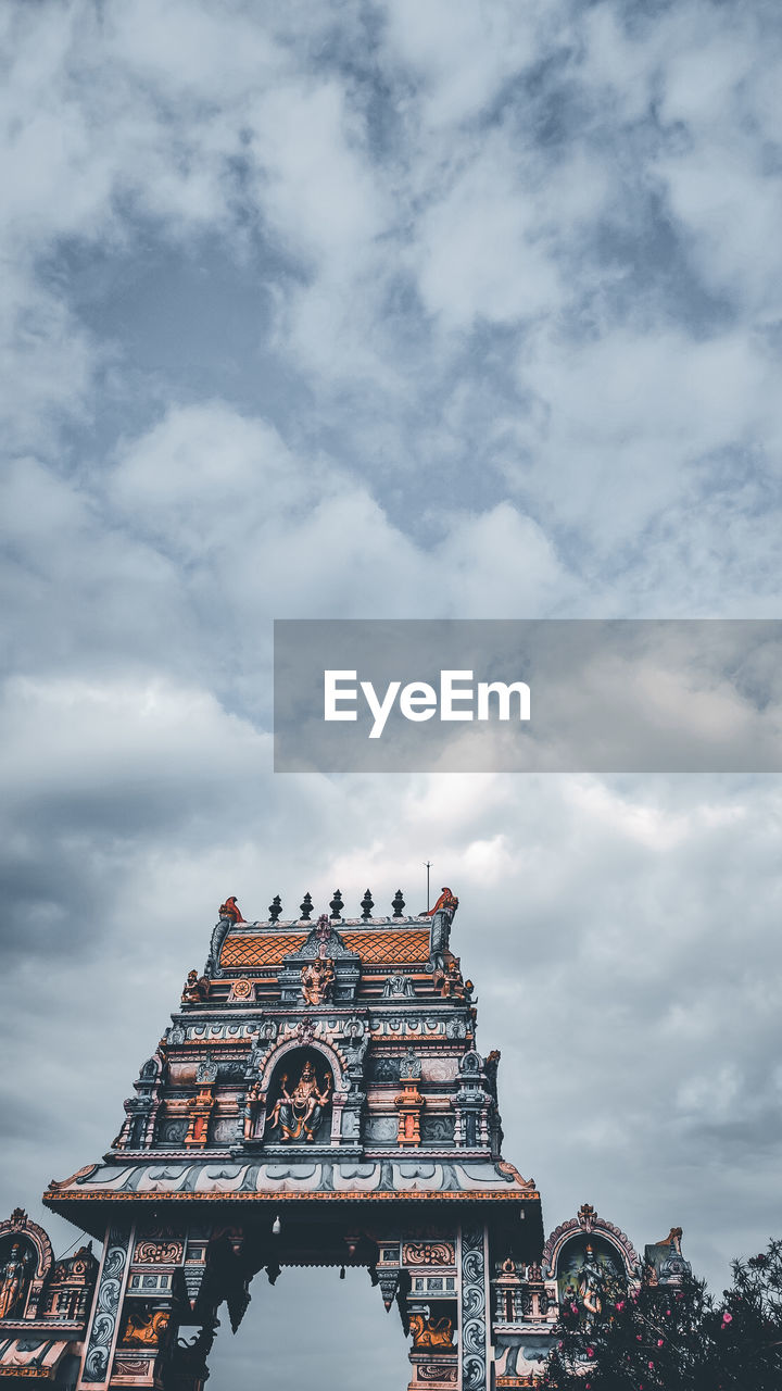 Low angle view of temple building against cloudy sky