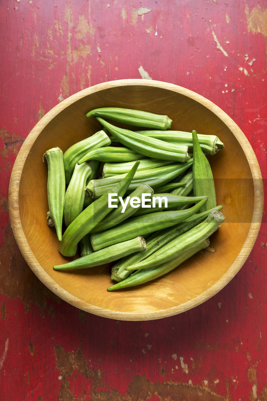 Okra in a bowl on a red table