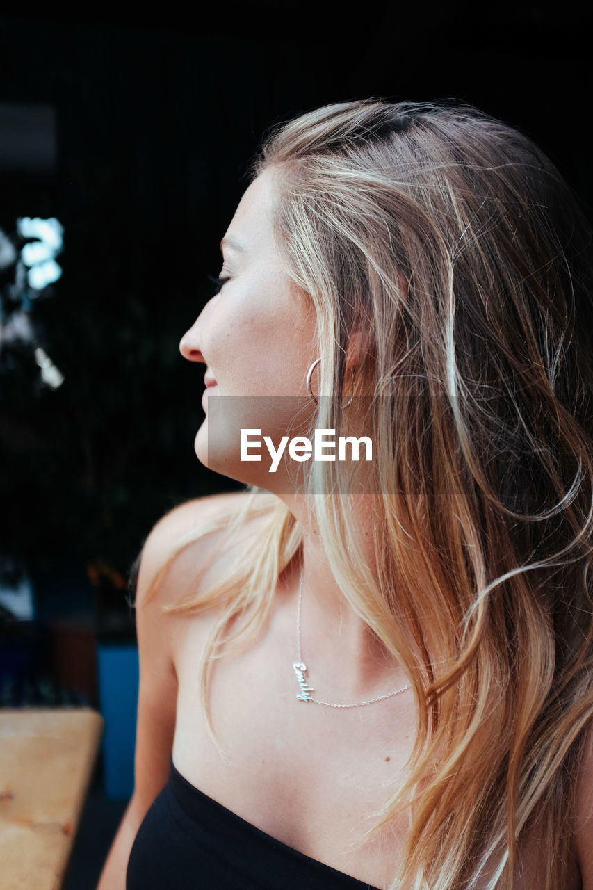 Close-up of smiling young woman looking away