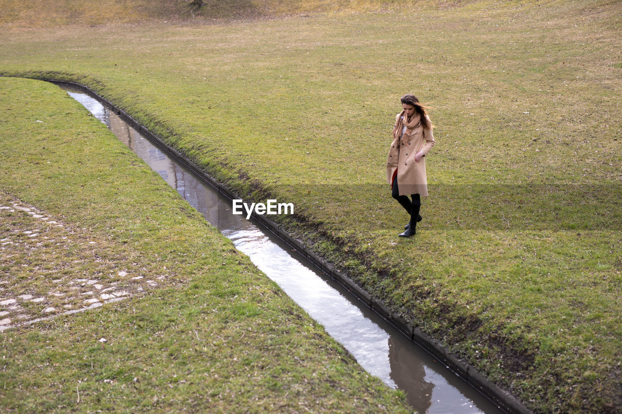 HIGH ANGLE VIEW OF MAN WALKING ON FOOTPATH