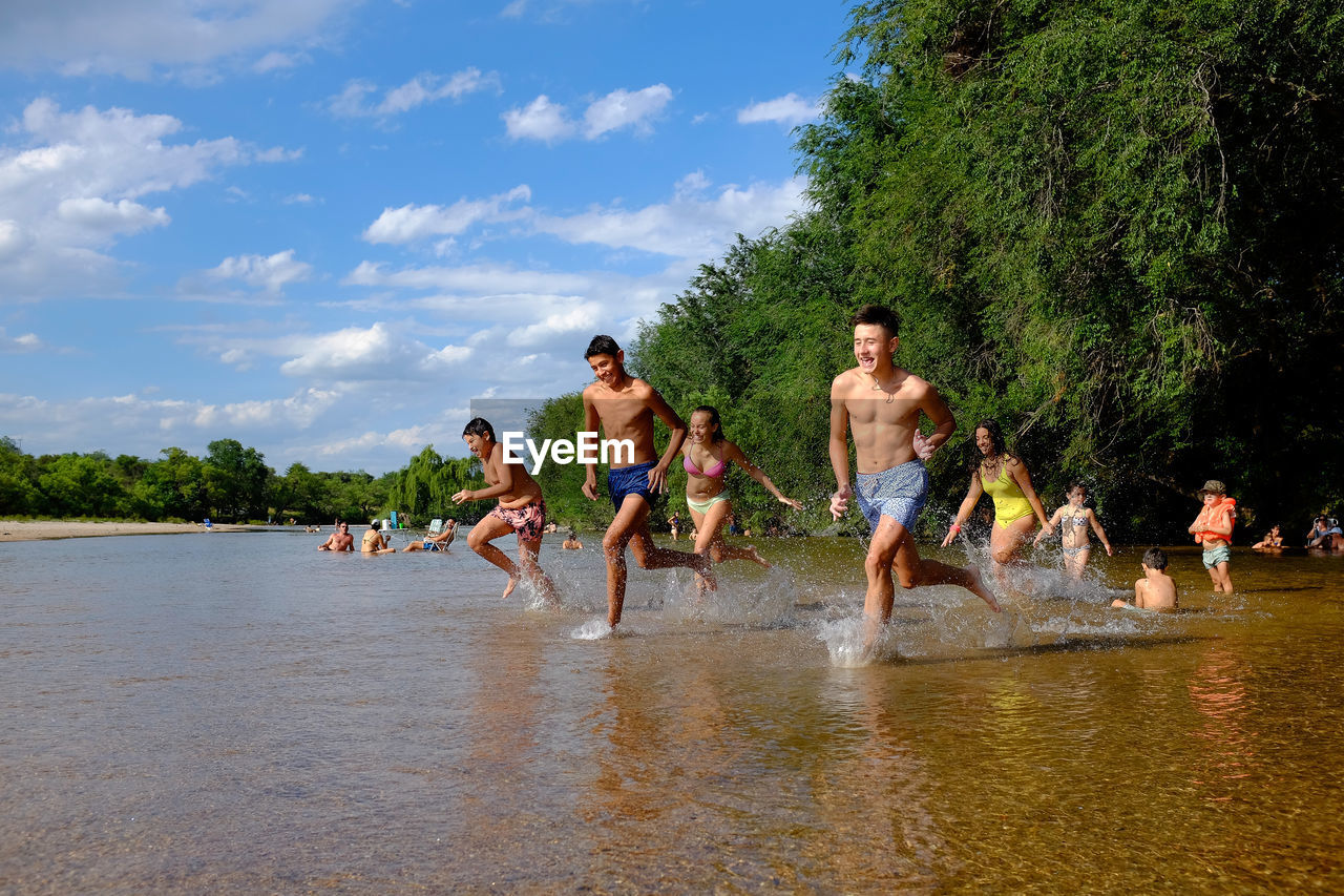 PEOPLE ENJOYING IN WATER AGAINST PLANTS