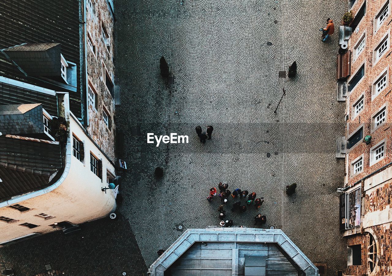 Directly above shot of people on city street amidst buildings