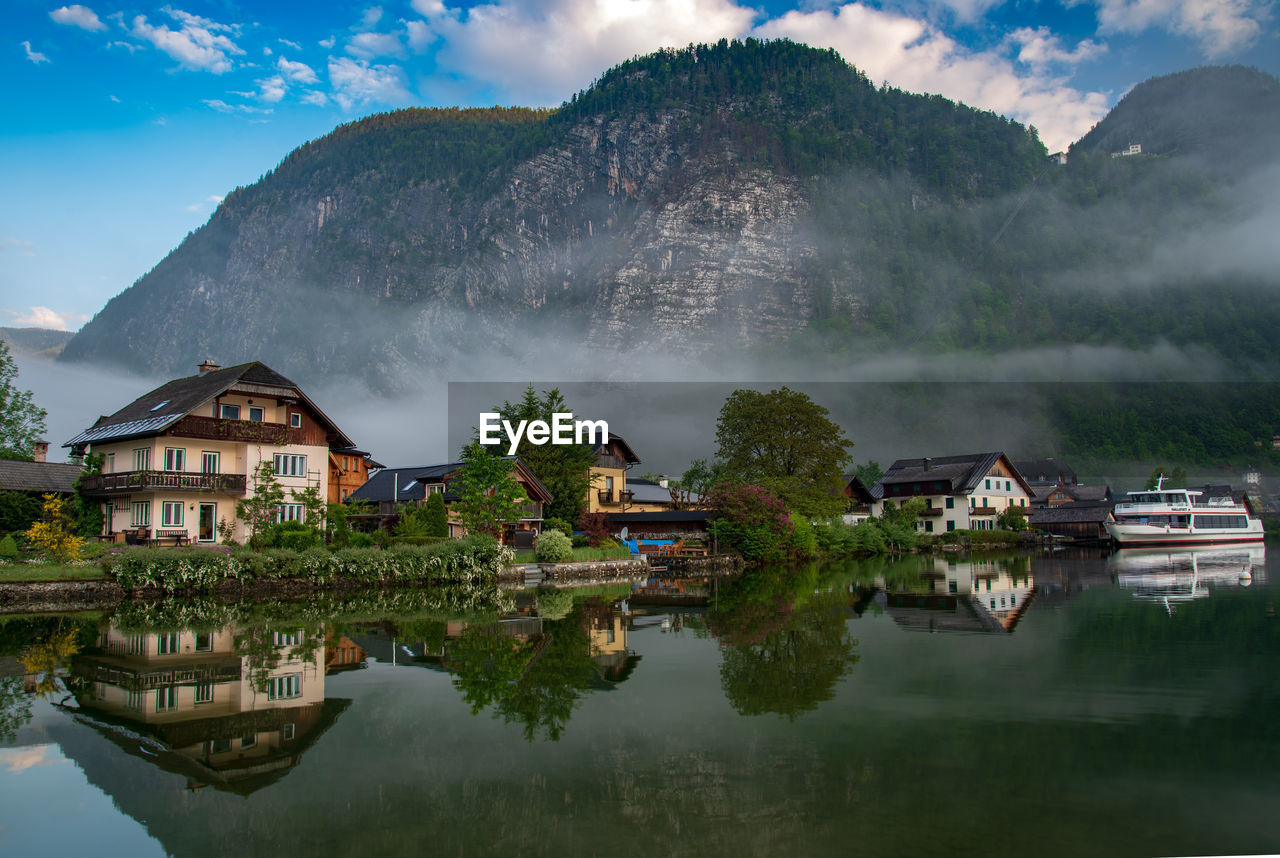 BUILDINGS BY LAKE AGAINST SKY