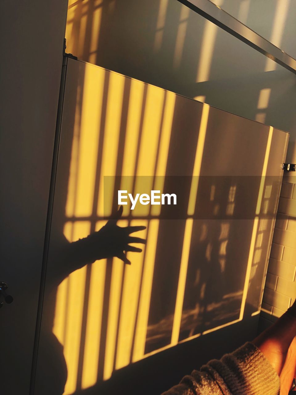 LOW ANGLE VIEW OF PERSON HAND ON WINDOW