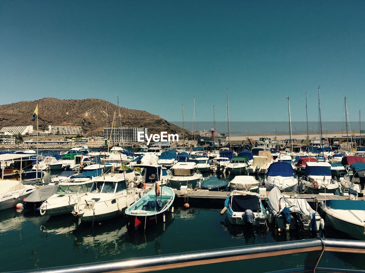 High angle view of boats moored at harbor against clear sky