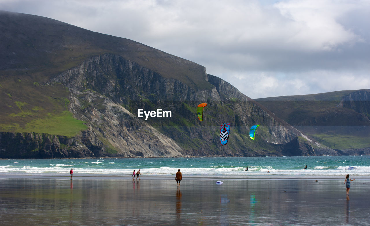 Scenic view of sea by mountains against sky