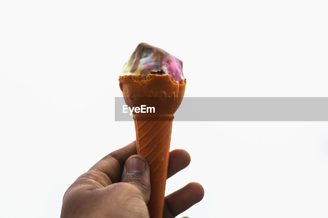 CLOSE-UP OF HAND HOLDING ICE CREAM CONE