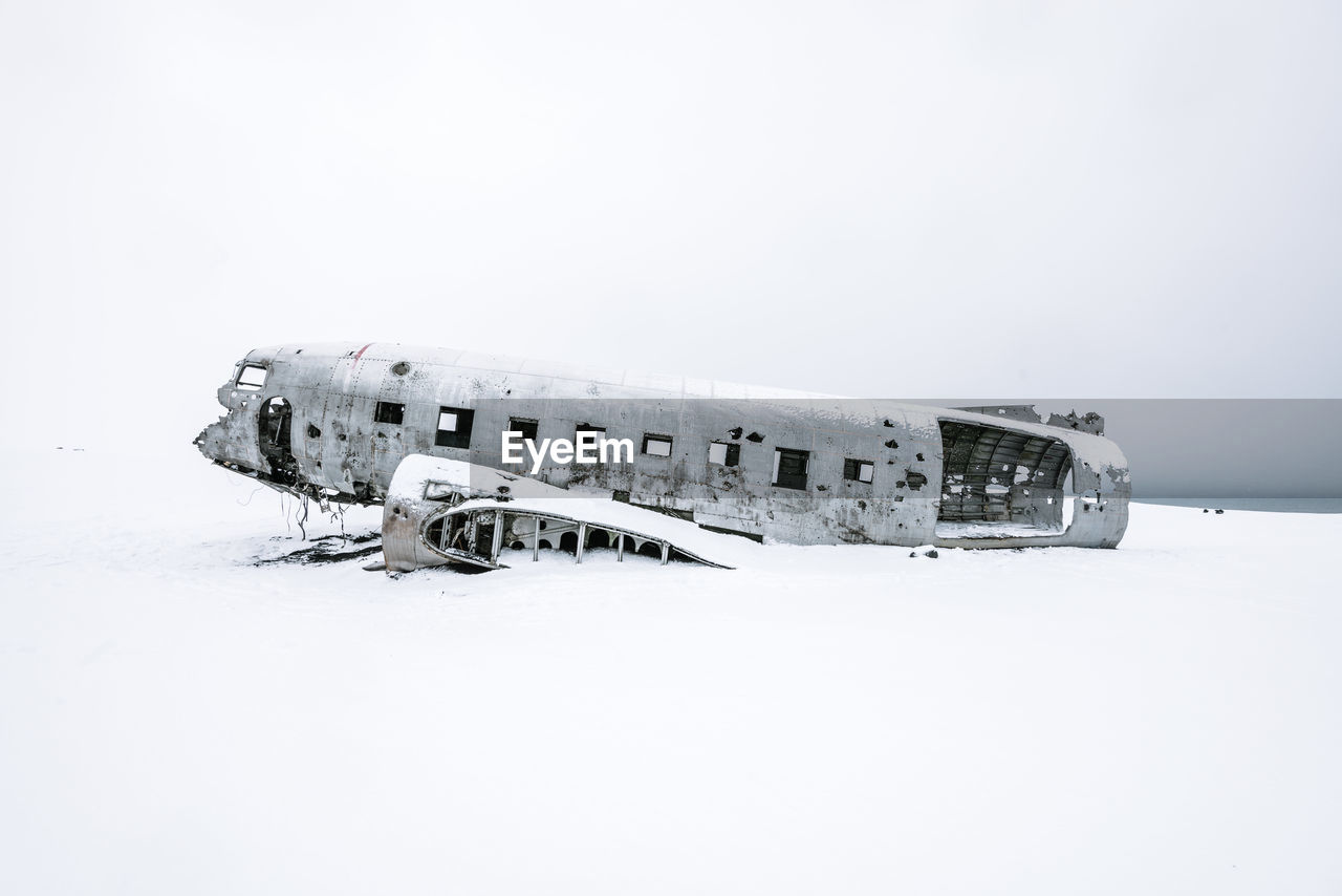 Abandoned airplane against clear sky during winter