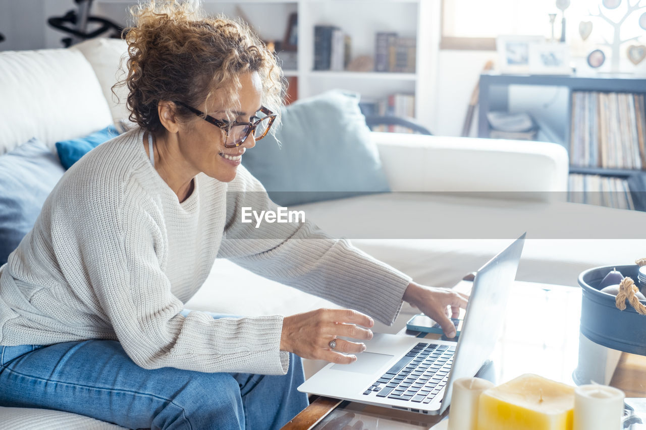 side view of young man using laptop at home