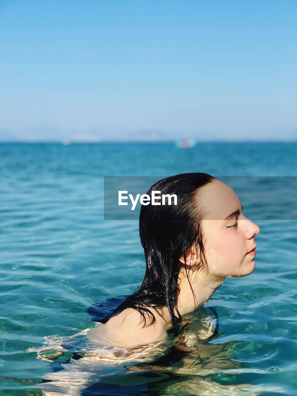 Woman swimming in pool against sea