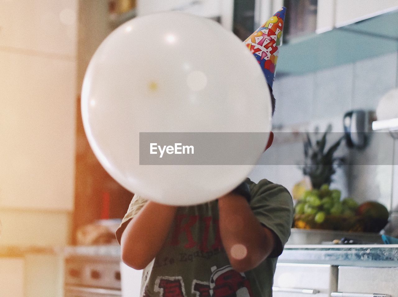 Boy with white balloon during birthday at home