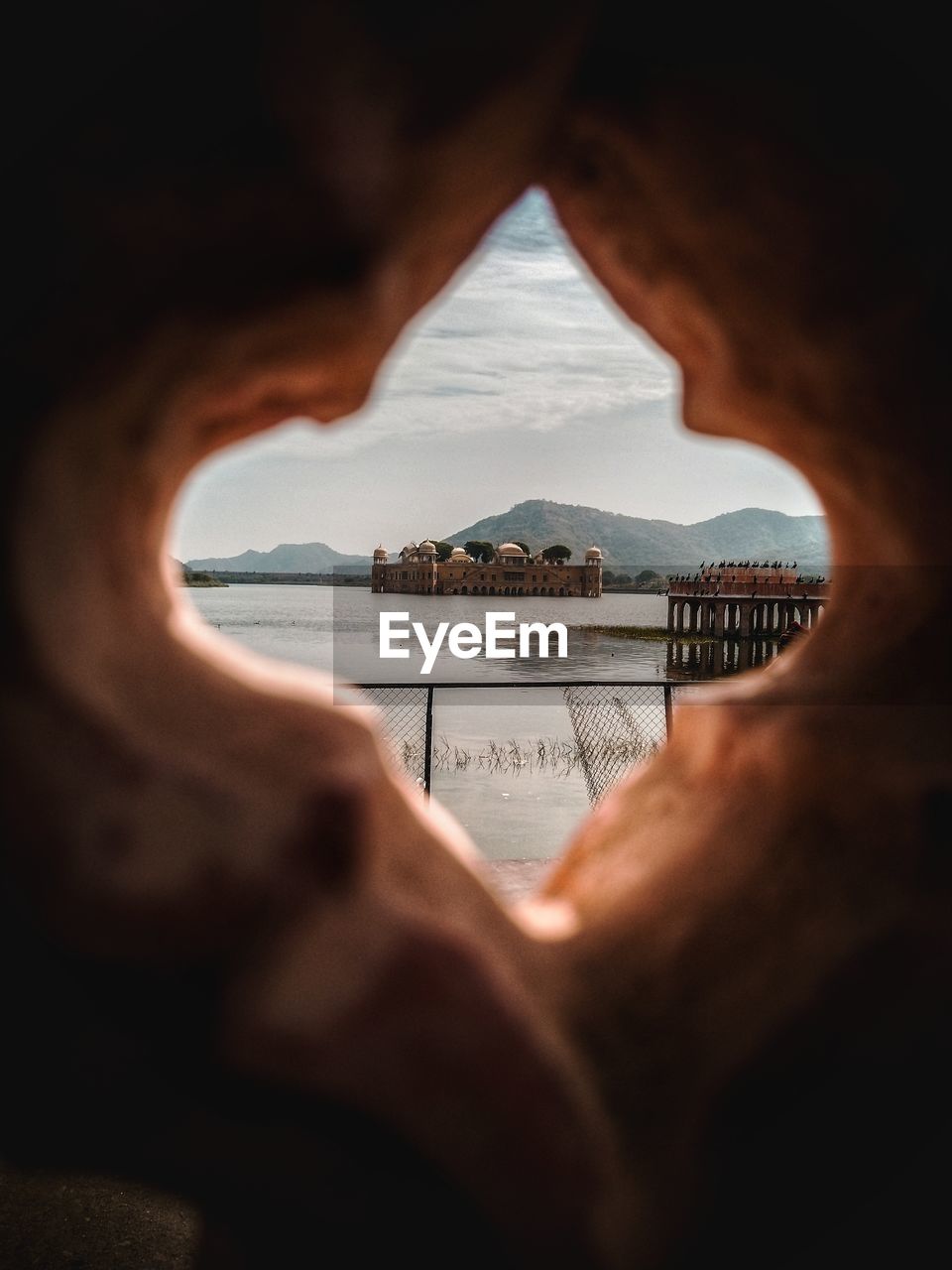 Historic building amidst lake seen through hole