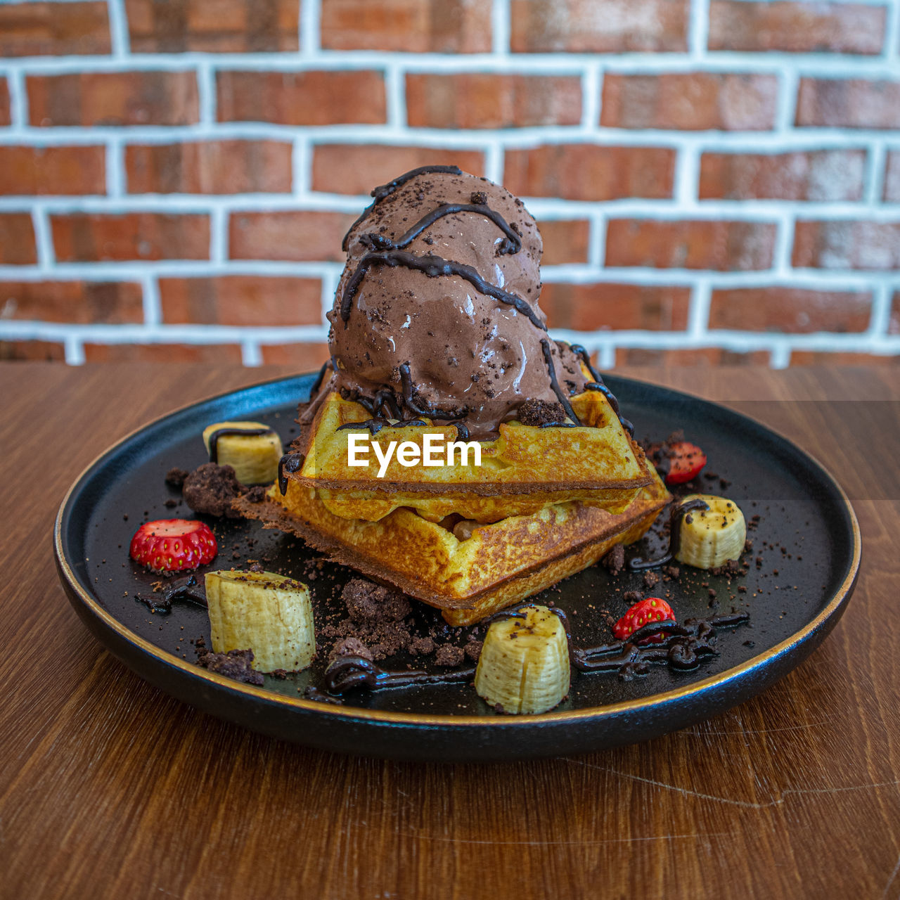 Close-up of dessert in plate on table against wall