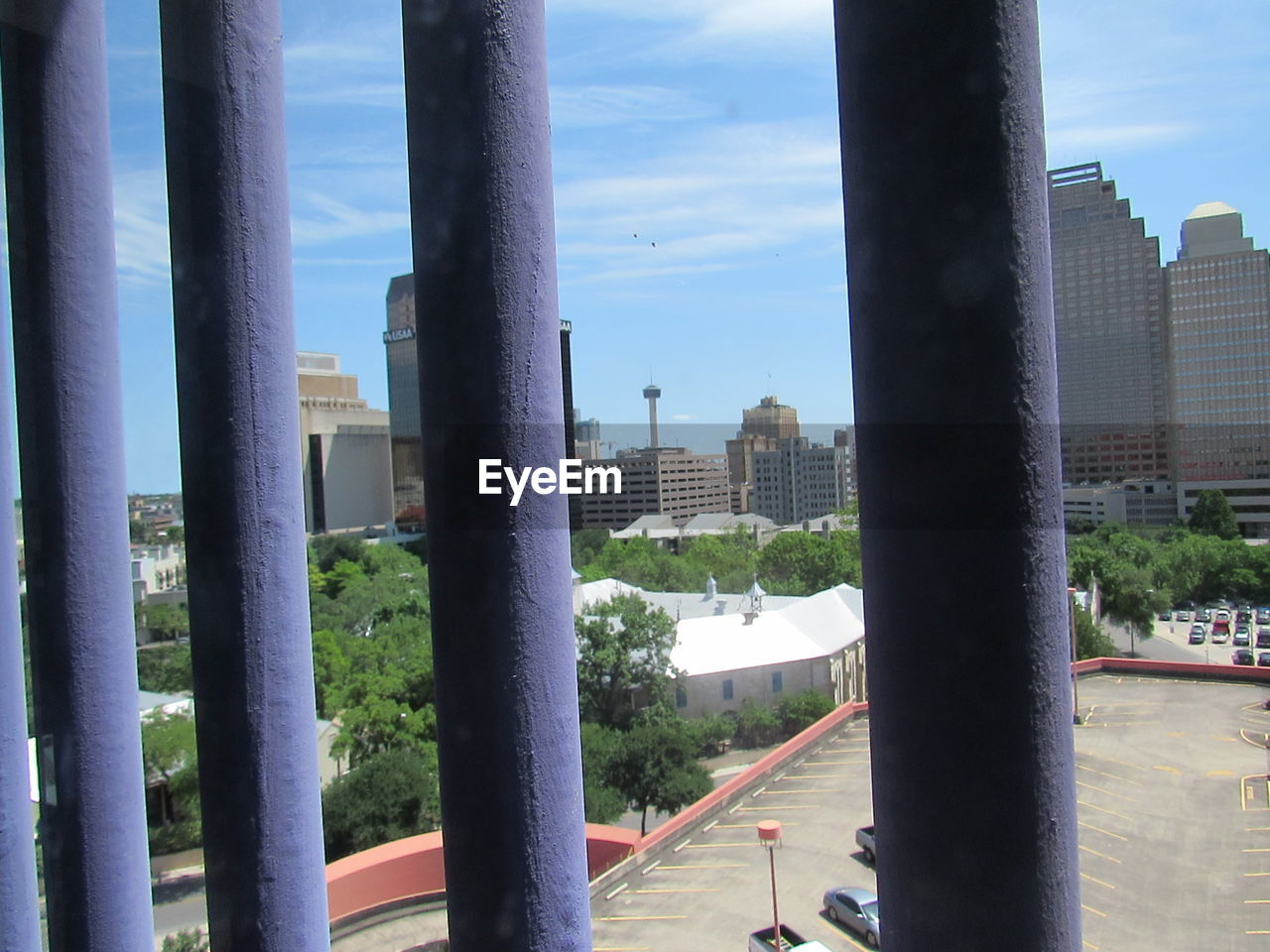 Buildings in city against sky seen through window