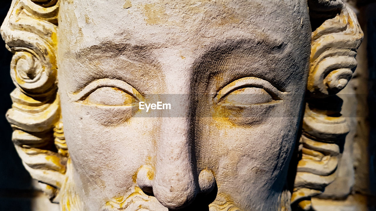 CLOSE-UP OF STATUE OF BUDDHA