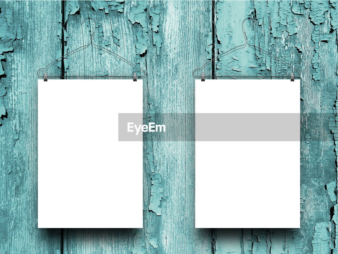 Blank papers hanging against wooden wall