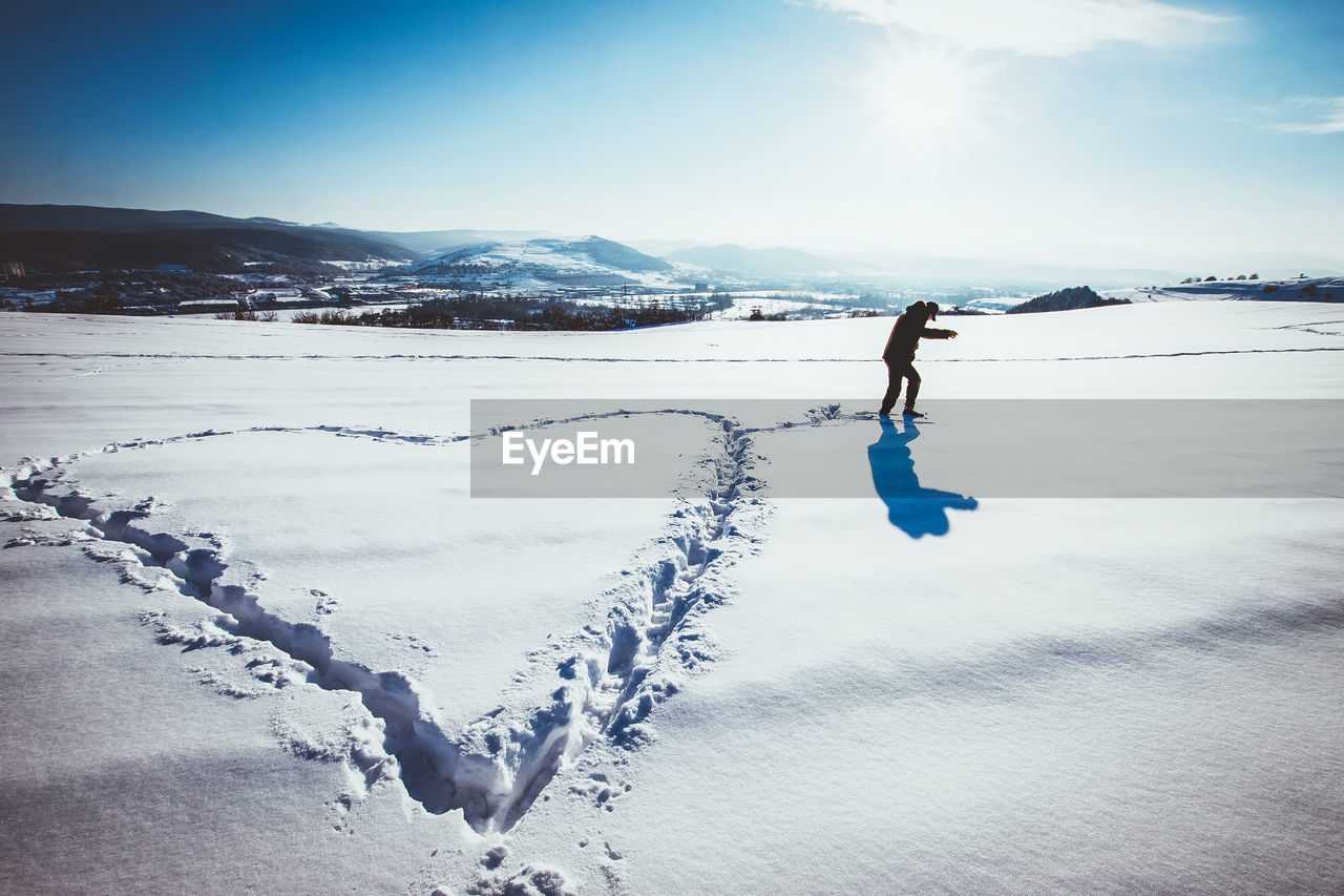 Full length of person on snow covered land against sky