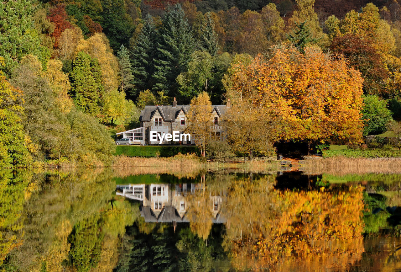 SCENIC VIEW OF LAKE BY TREES AGAINST BUILDING DURING AUTUMN