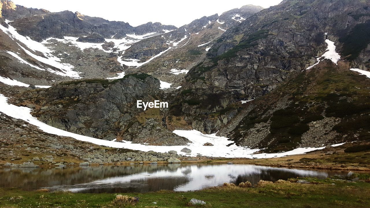 SCENIC VIEW OF LAKE BY SNOW MOUNTAINS AGAINST SKY