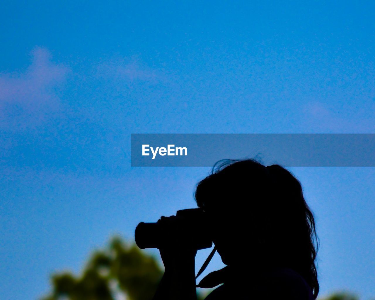 LOW ANGLE VIEW OF WOMAN STANDING AGAINST SKY