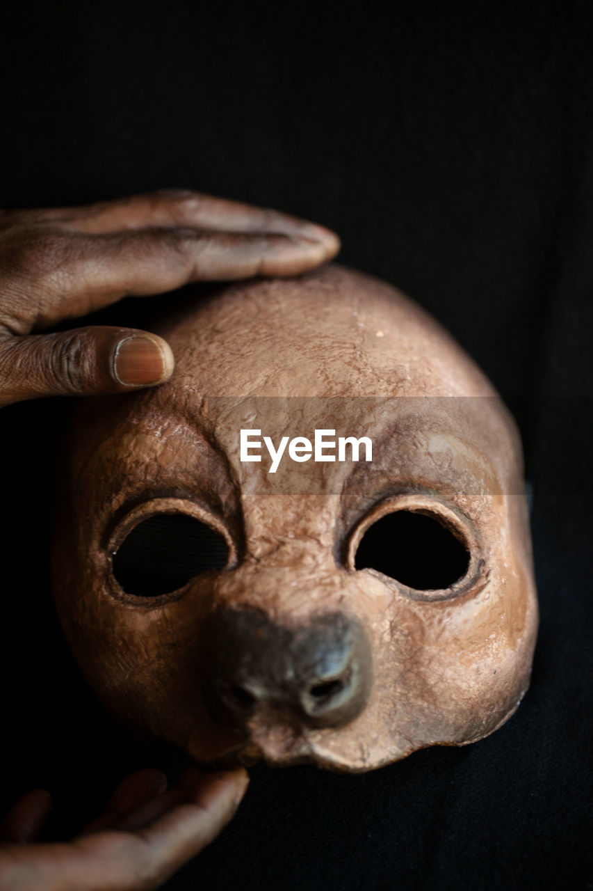 Close-up portrait of human hand against black background